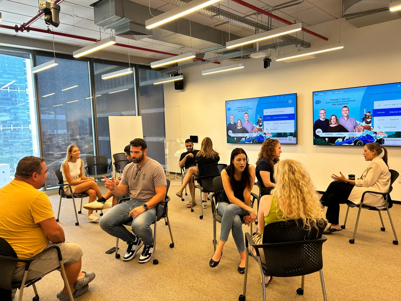 משתתפים יושבים במעגל ומשוחחים בסדנת הקשבה של Kenvé, אור טבעי וחלונות גדולים.